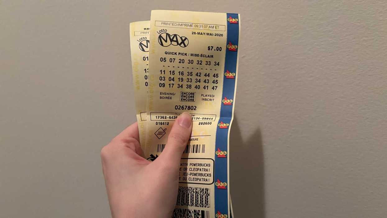 person holding two lotto max tickets