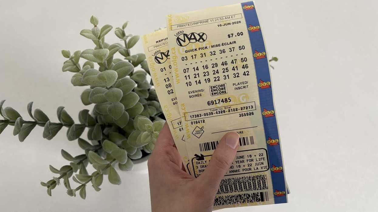 person holding two lotto max tickets