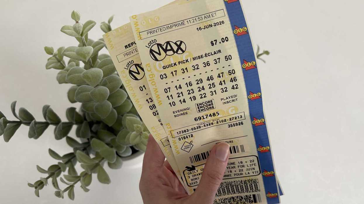 person holding two lotto max tickets