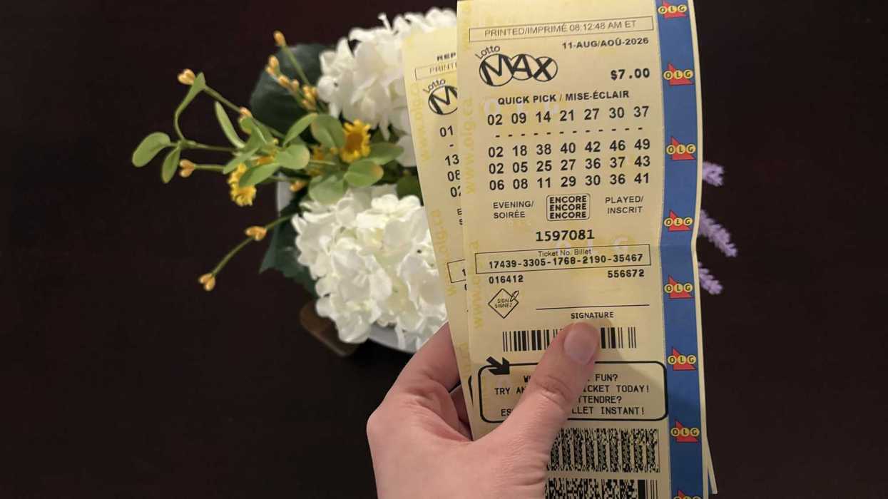 person holding two lotto max tickets