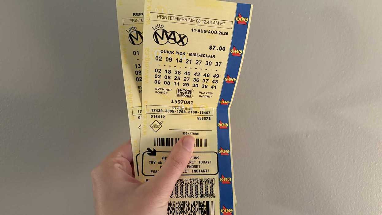 person holding two lotto max tickets