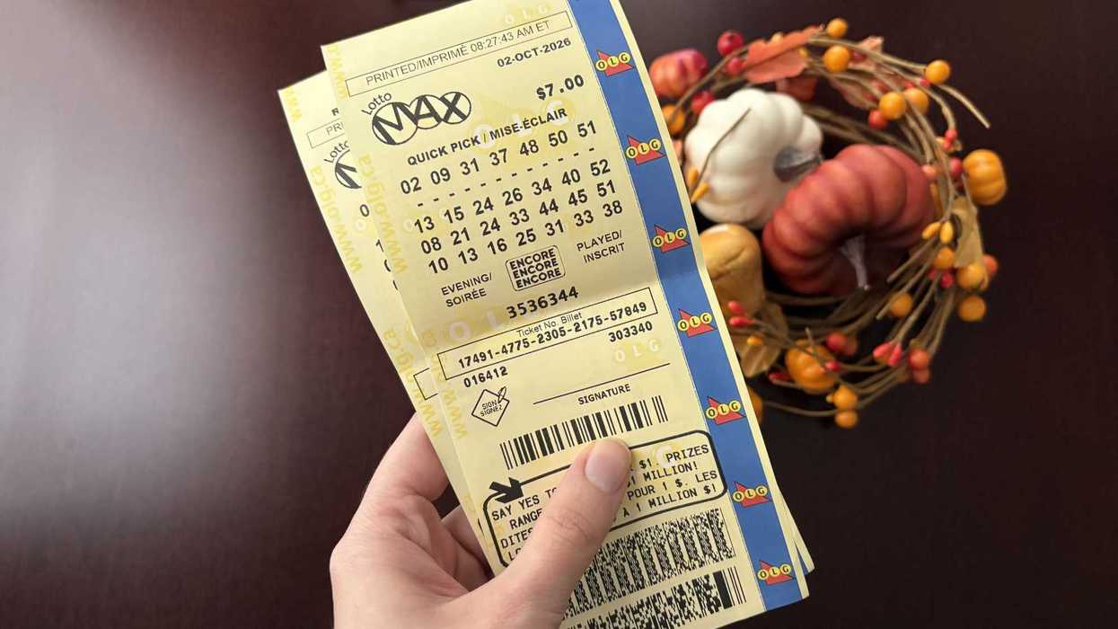 person holding two lotto max tickets