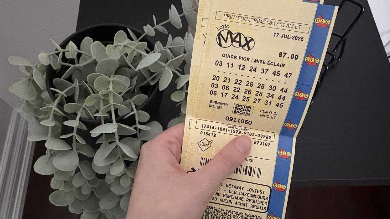 person holding two old lotto max tickets