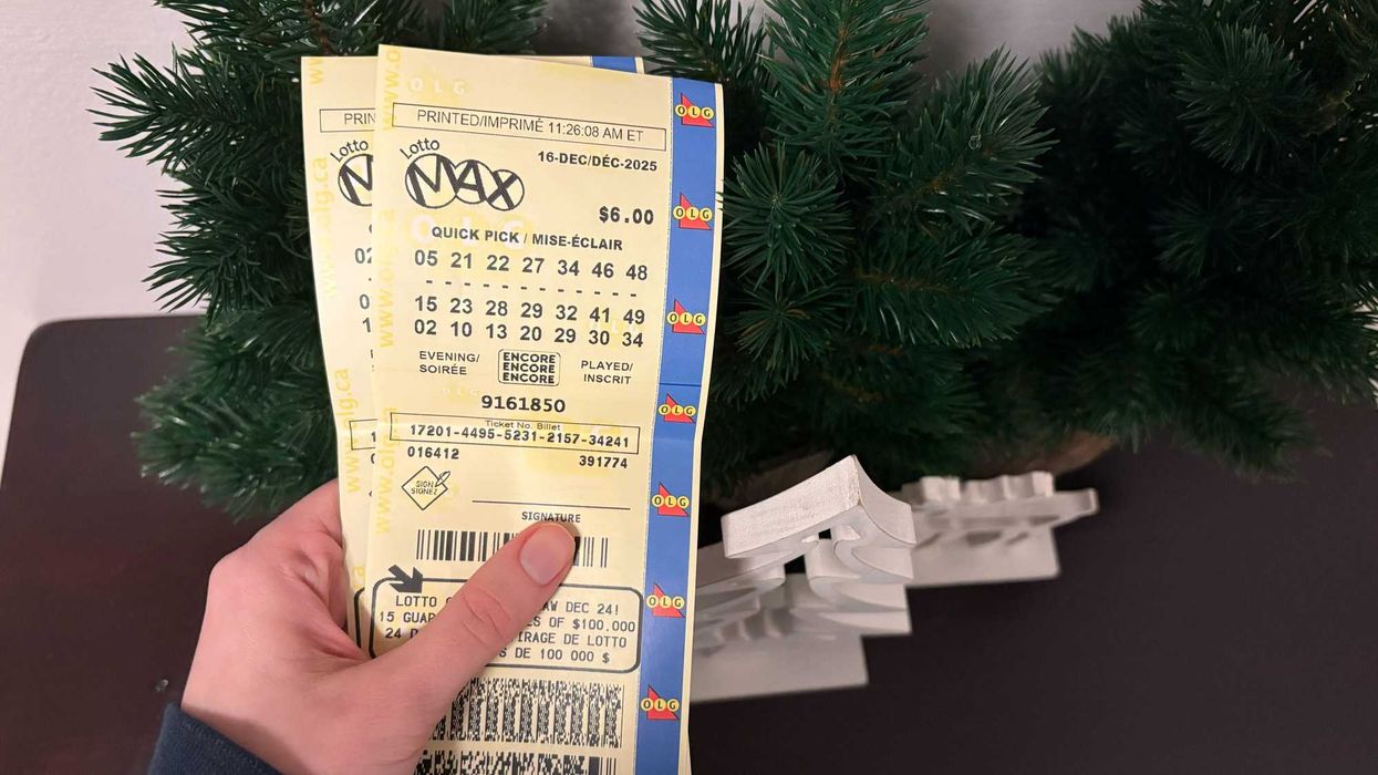 person holding two olg lotto max tickets