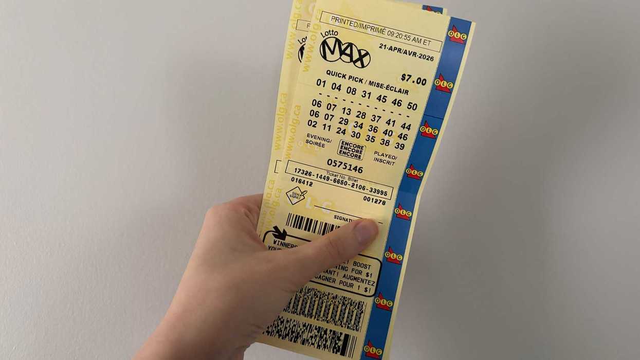 person holding two olg lotto max tickets