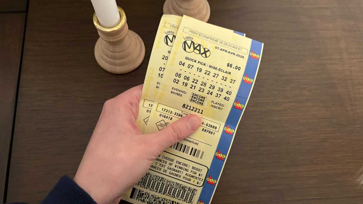 person holding two olg lotto max tickets