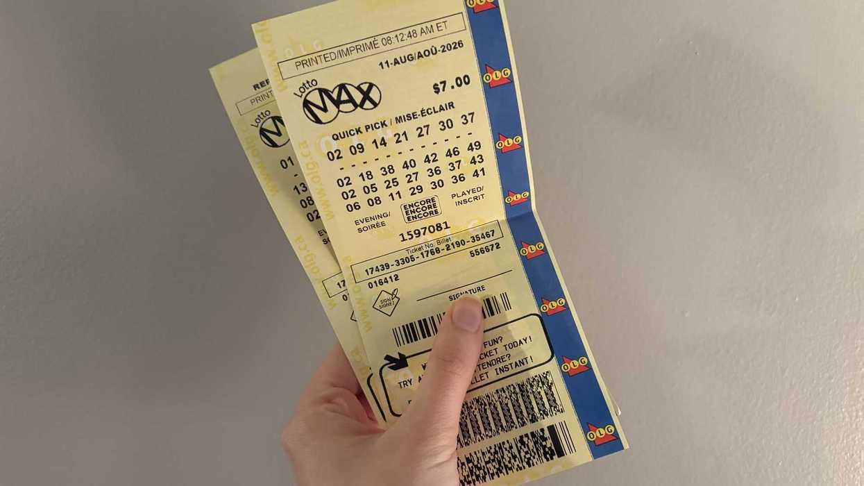 person holding two olg lotto max tickets