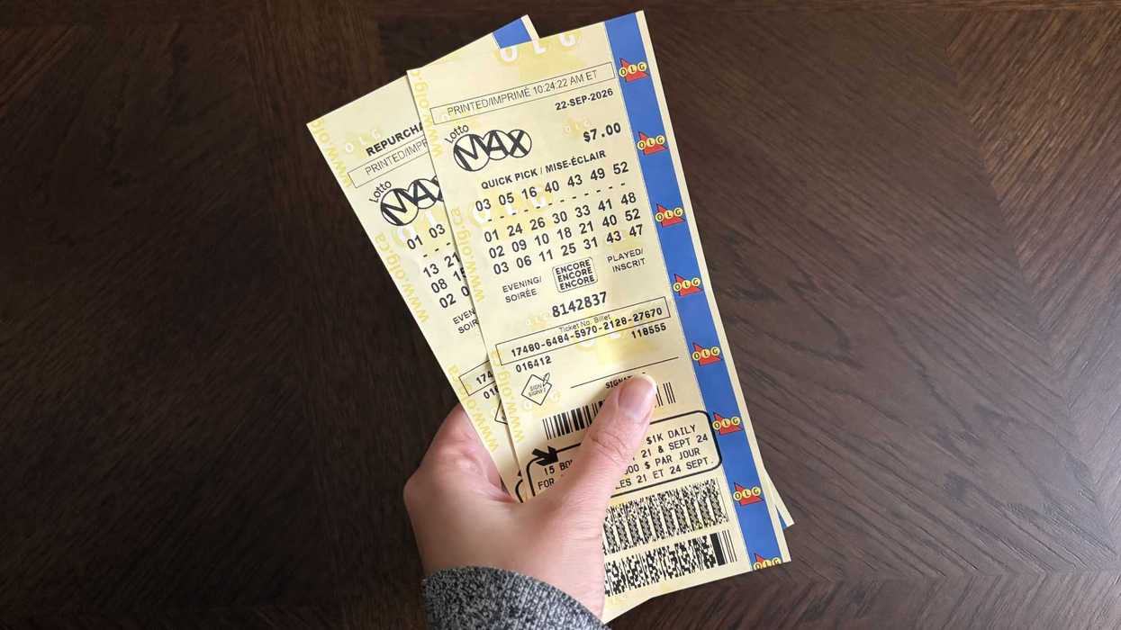 person holding two olg lotto max tickets