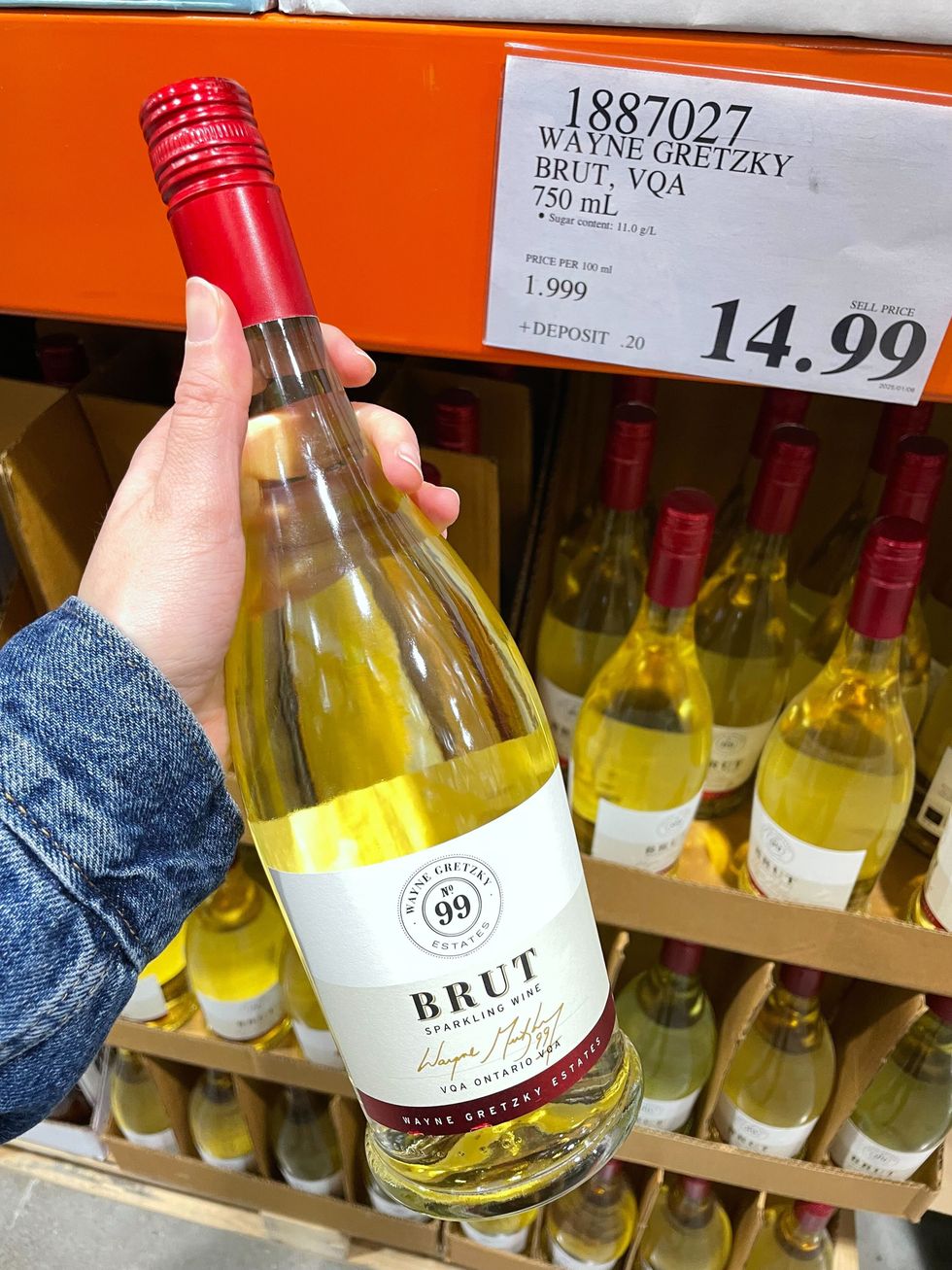 person holding wayne gretzky estates brut sparkling wine at costco