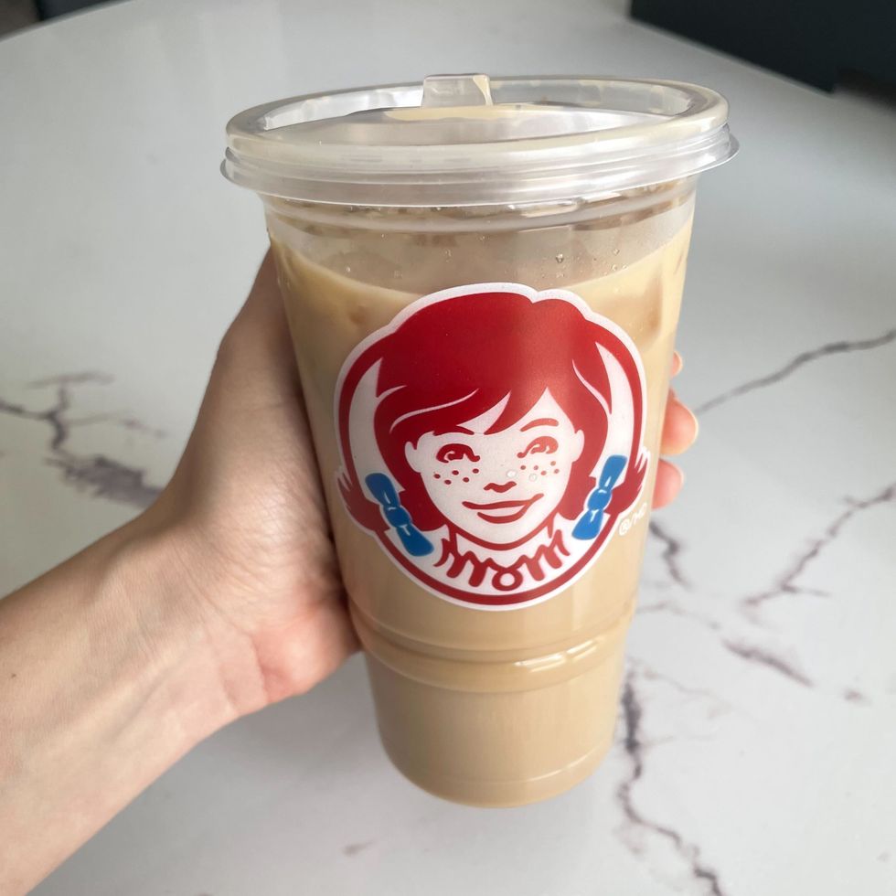 person holding wendy's iced coffee