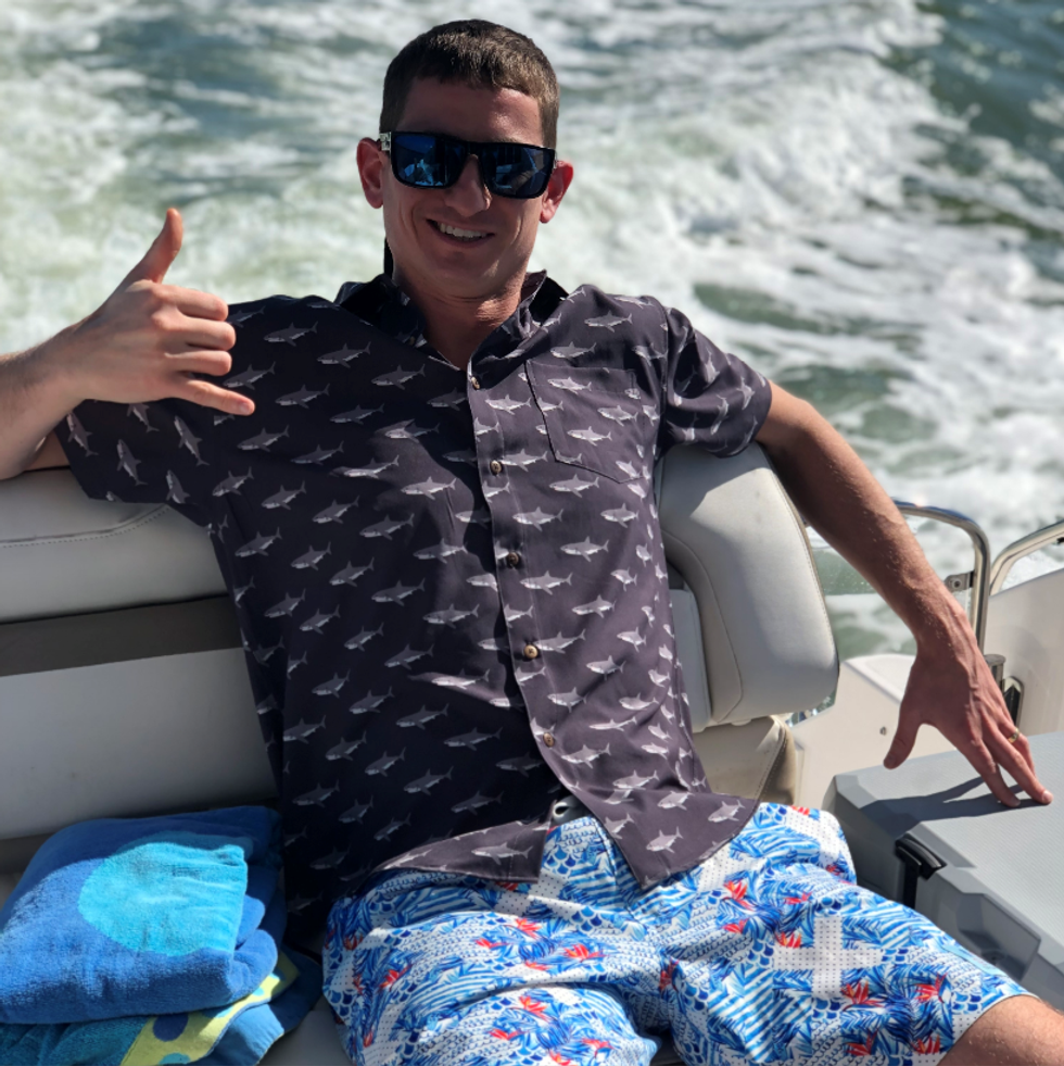 person sitting in boat wearing the shark shirt