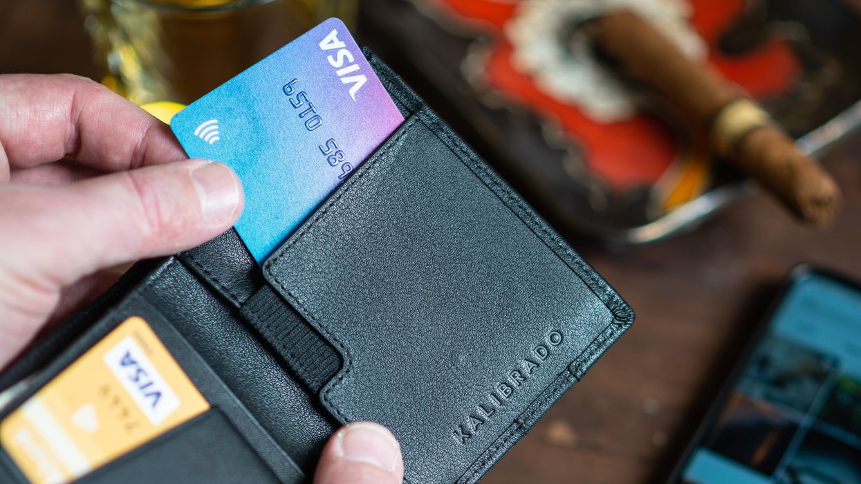 Person taking a credit card out of a wallet.