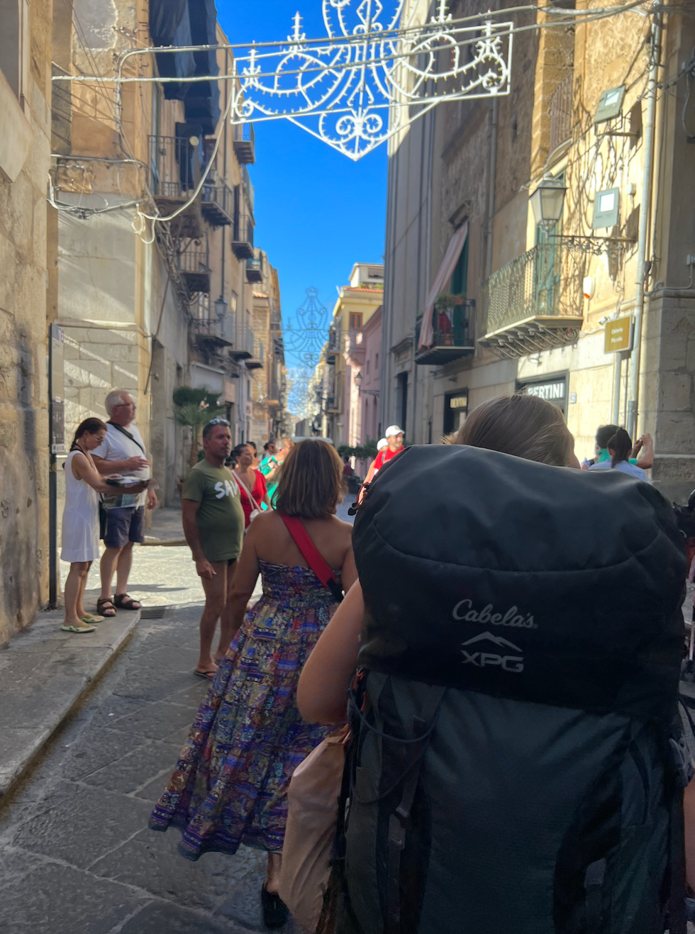Person walking down a street with a big backpack.