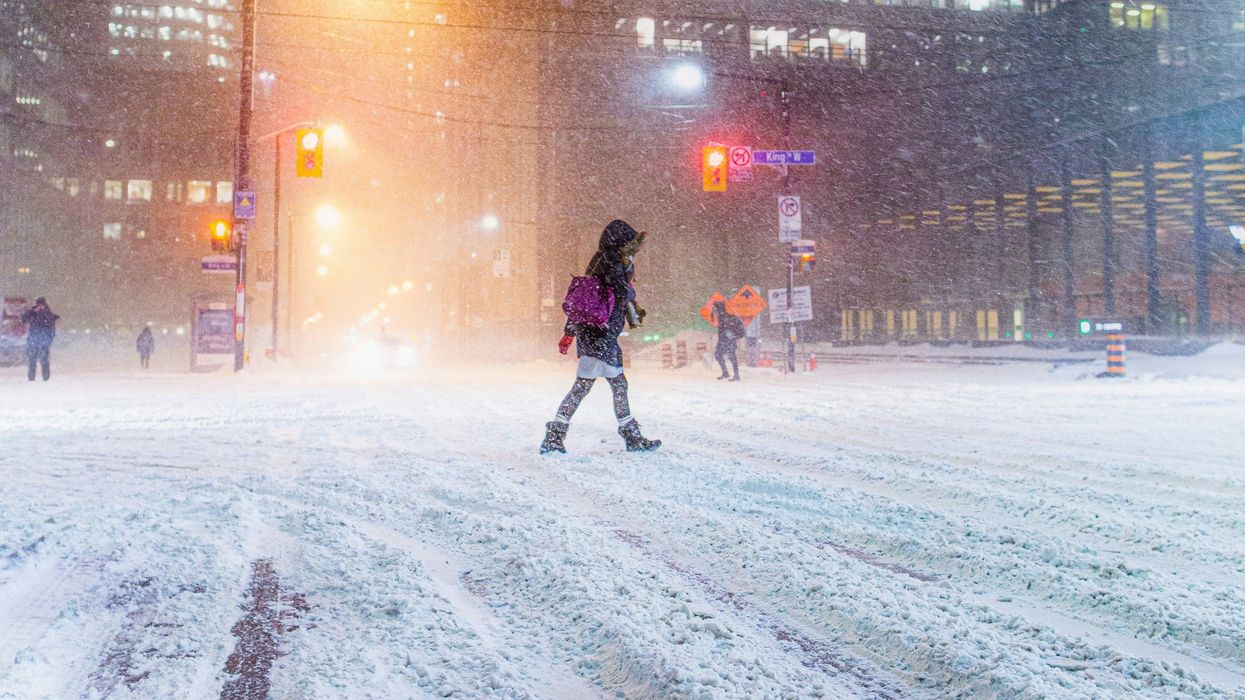 person walking on toronto street during snowstomr