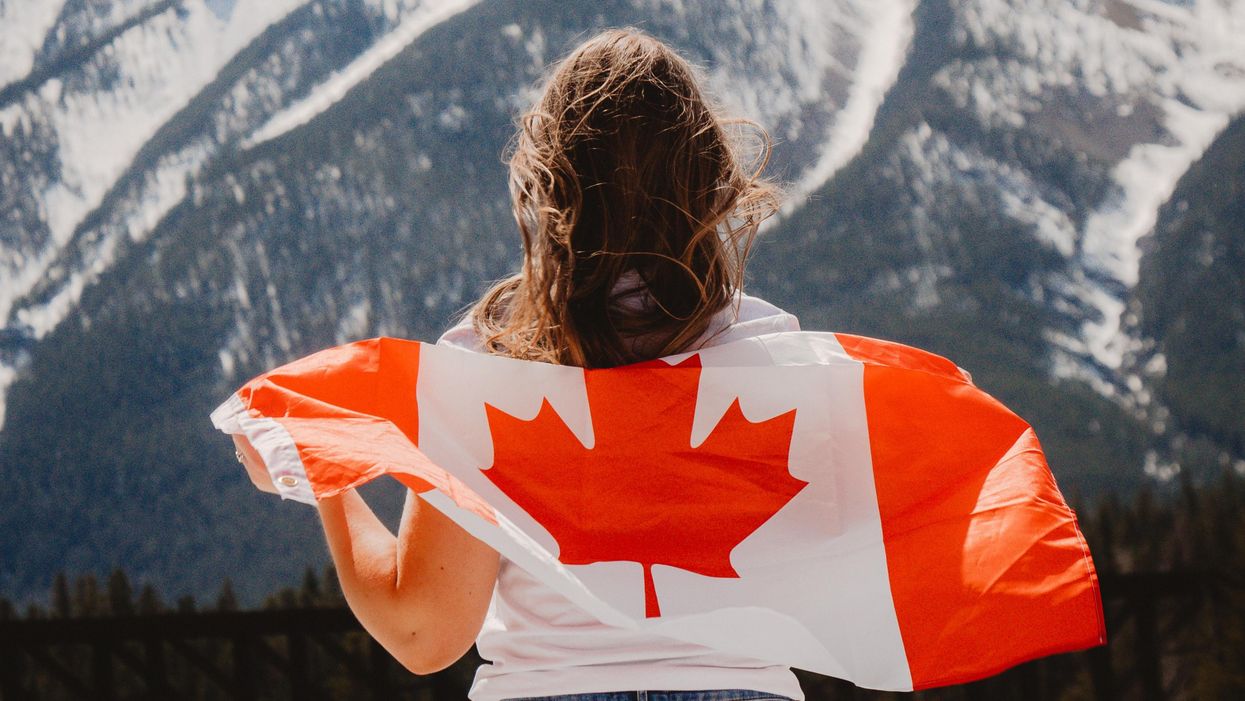 Person with a Canadian flag draped over their back.