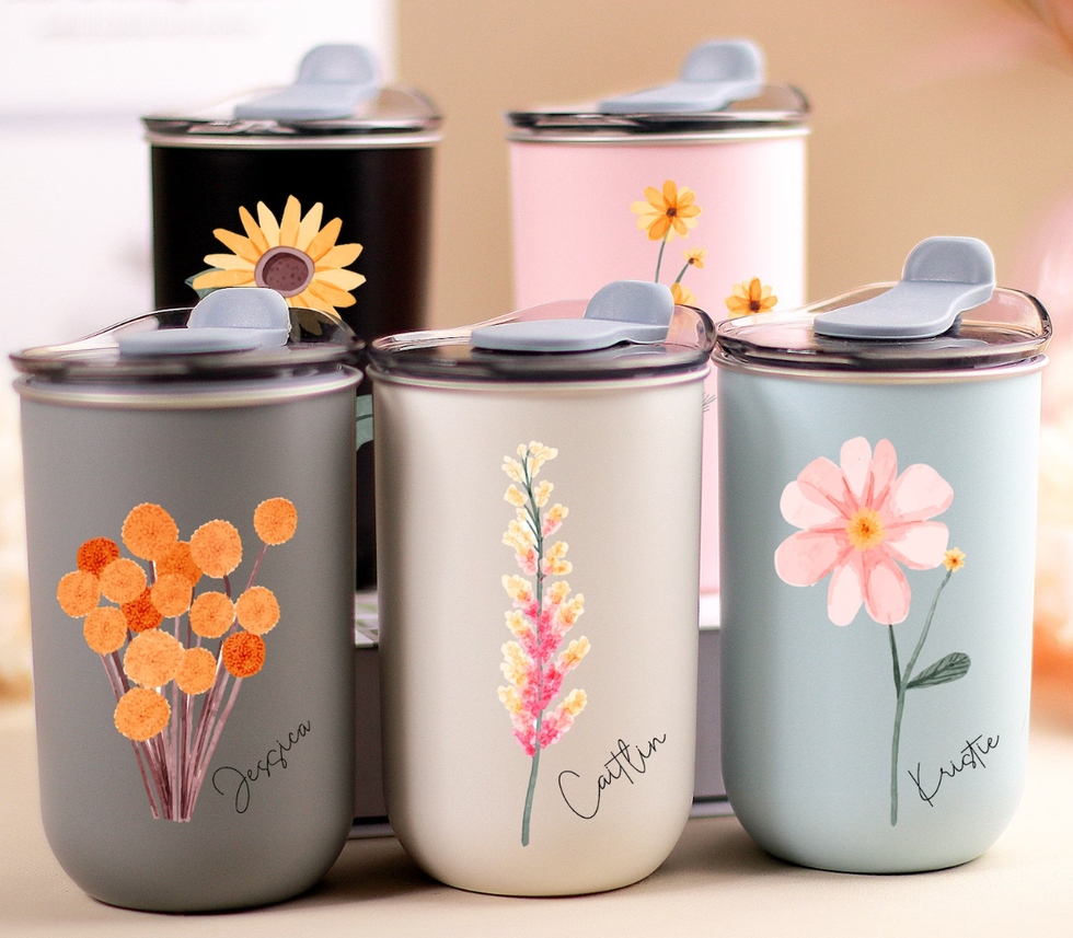 Personalized tumblers in various colours with flowers and names printed on them.