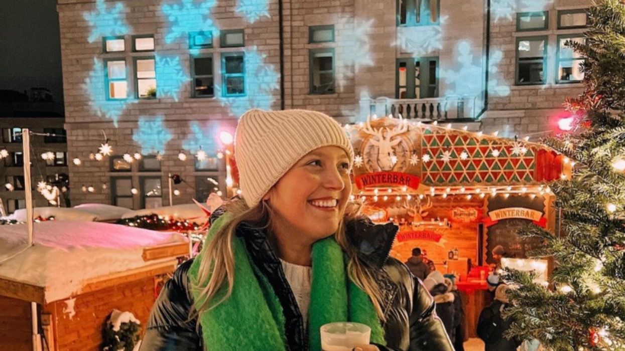 Personne se tenant devant un sapin illuminé au Marché de Noël allemand de Québec.