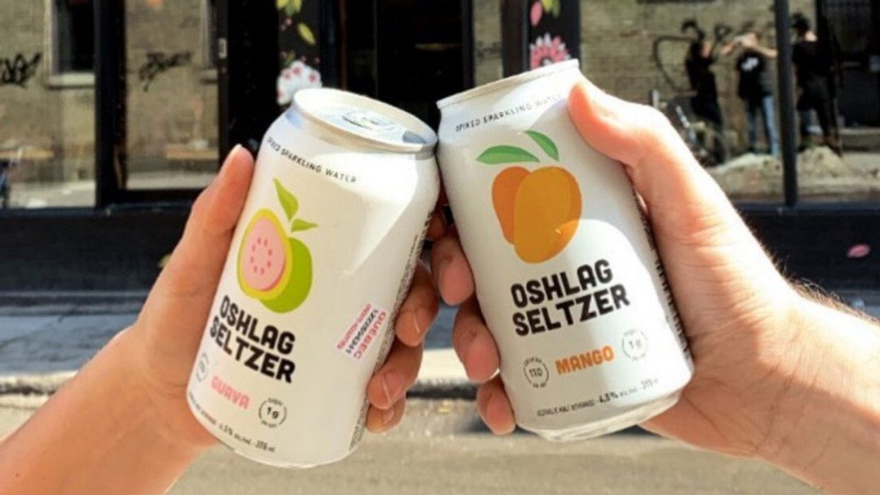 Personnes tenant deux canettes de Oshlag Seltzer.