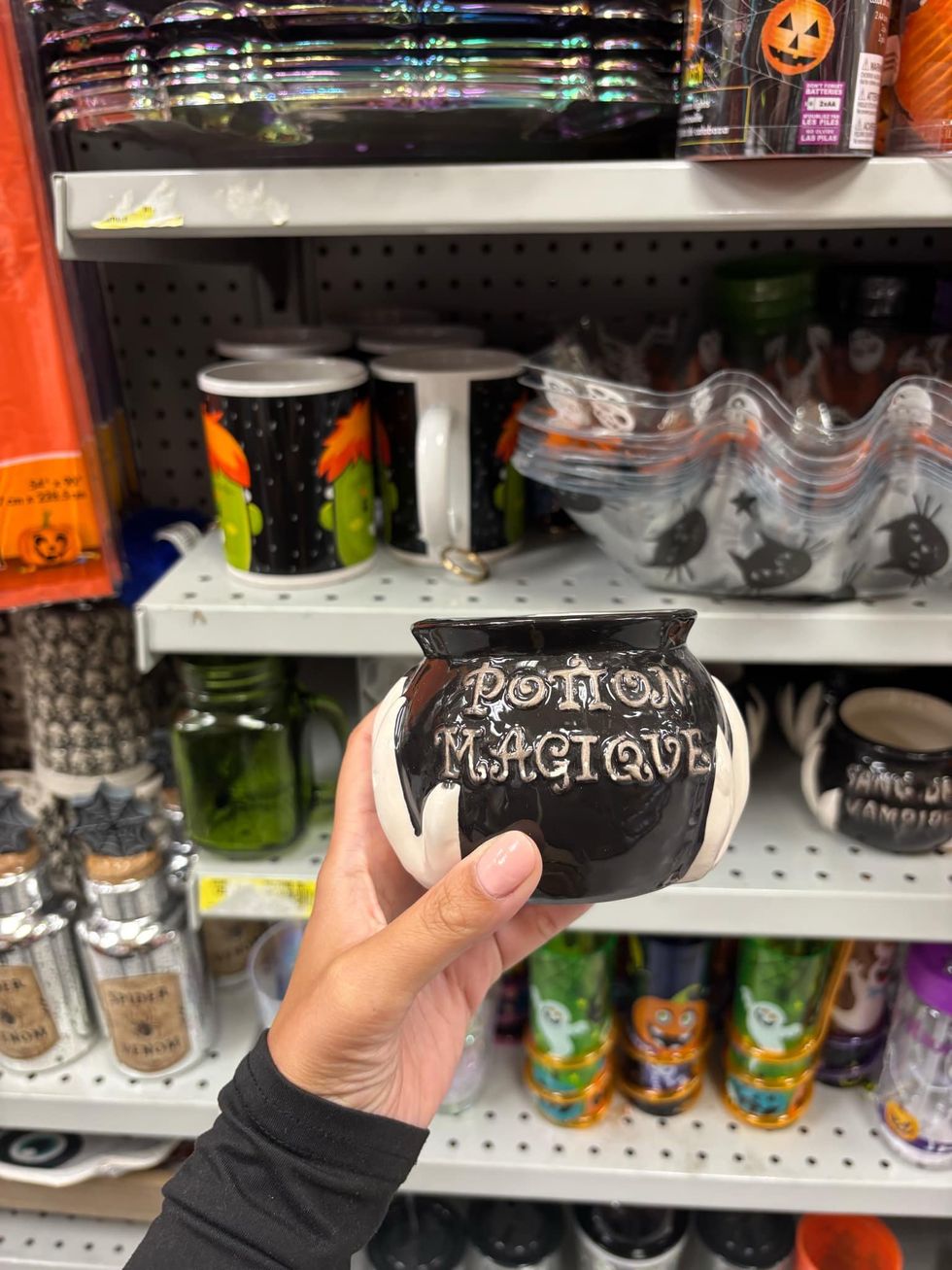 Petit pot noir en forme de chaudron de sorci\u00e8re.