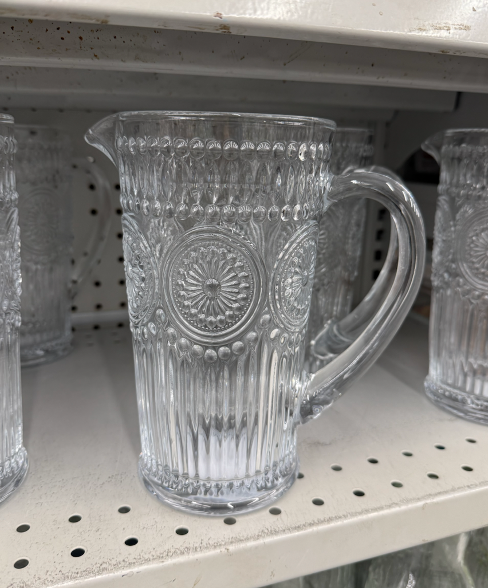 Pichet en verre transparent avec motifs textur\u00e9s expos\u00e9 sur une tablette chez Dollarama.
