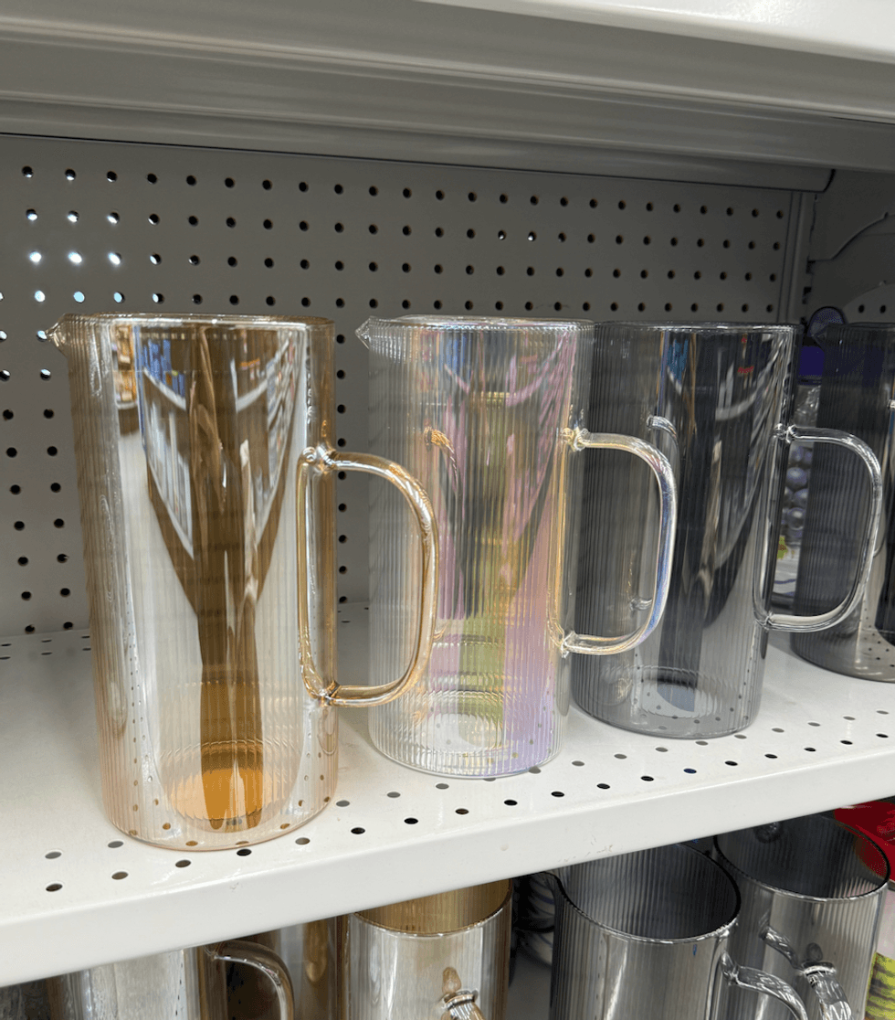 Pichets en verre stri\u00e9 avec anse et bec verseur, offerts en ambr\u00e9, iridescent et gris fum\u00e9, vendus 5 $ chez Dollarama.