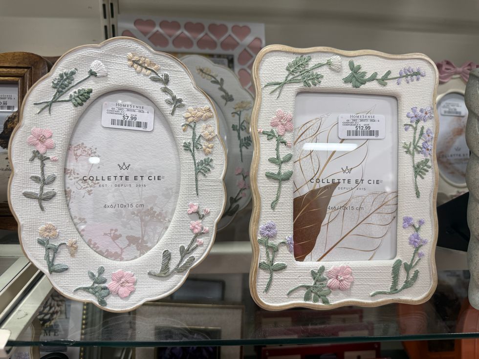 Picture frames with flowers on them on a store shelf.