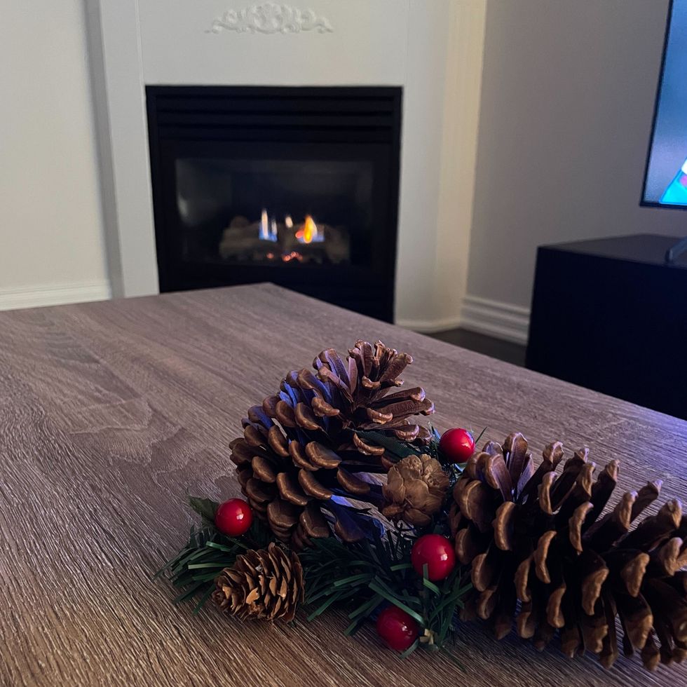 pinecone dollarama christmas decorations on a wooden table with a fireplace in the background