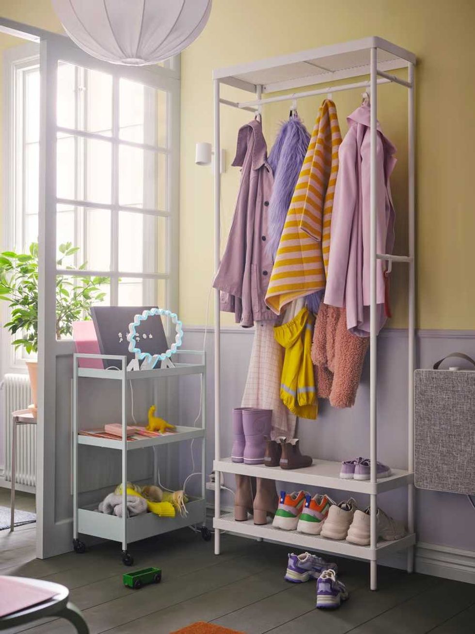 Pink, yellow, orange and purple clothes and accessories arranged in the MACKAP\u00c4R storage series.