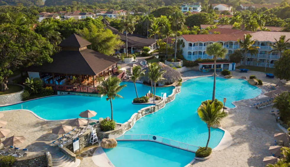 Piscines entour\u00e9es de palmiers, de ponts et d\u2019espaces d\u00e9tente, au c\u0153ur du Lifestyle Tropical Beach Resort and Spa.