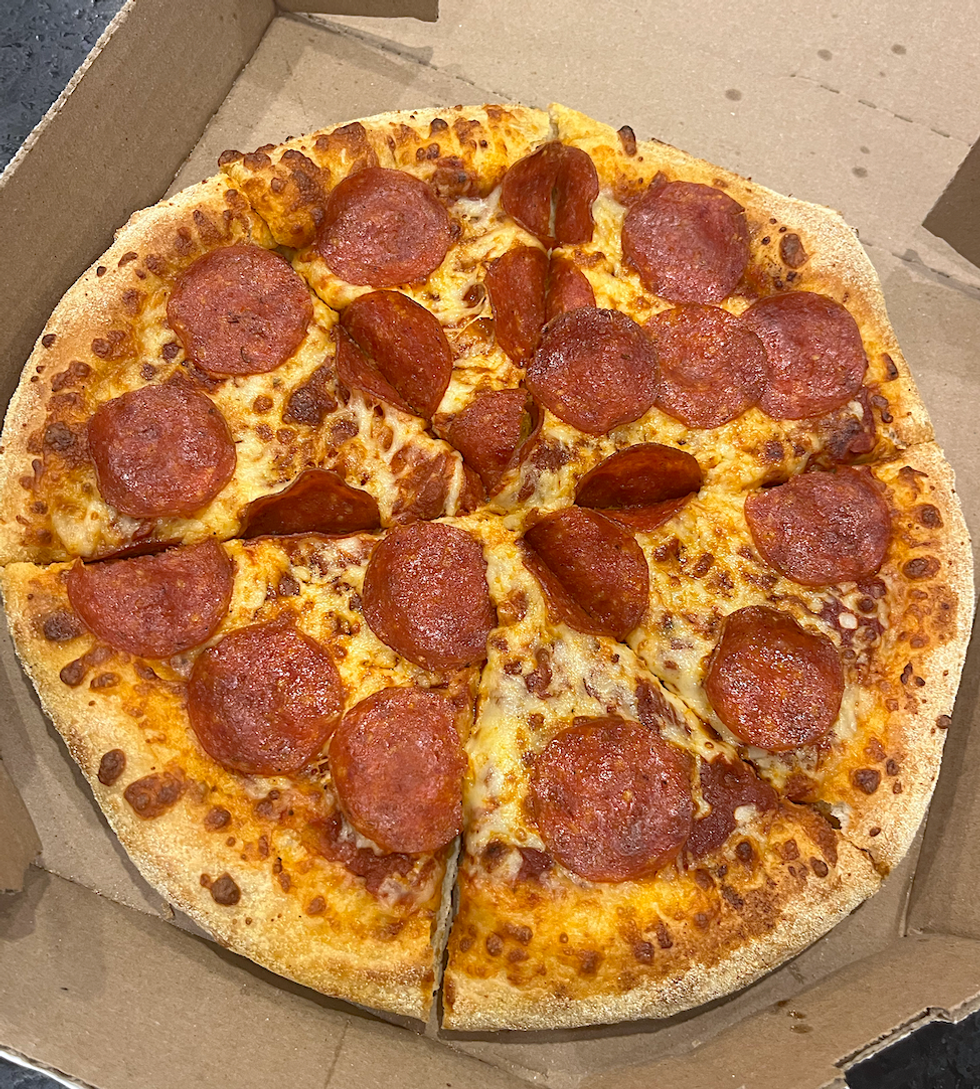 Pizza au pepperoni et fromage dans sa bo\u00eete : elle semble app\u00e9tissante et g\u00e9n\u00e9reuse en nombre de pepperonis.