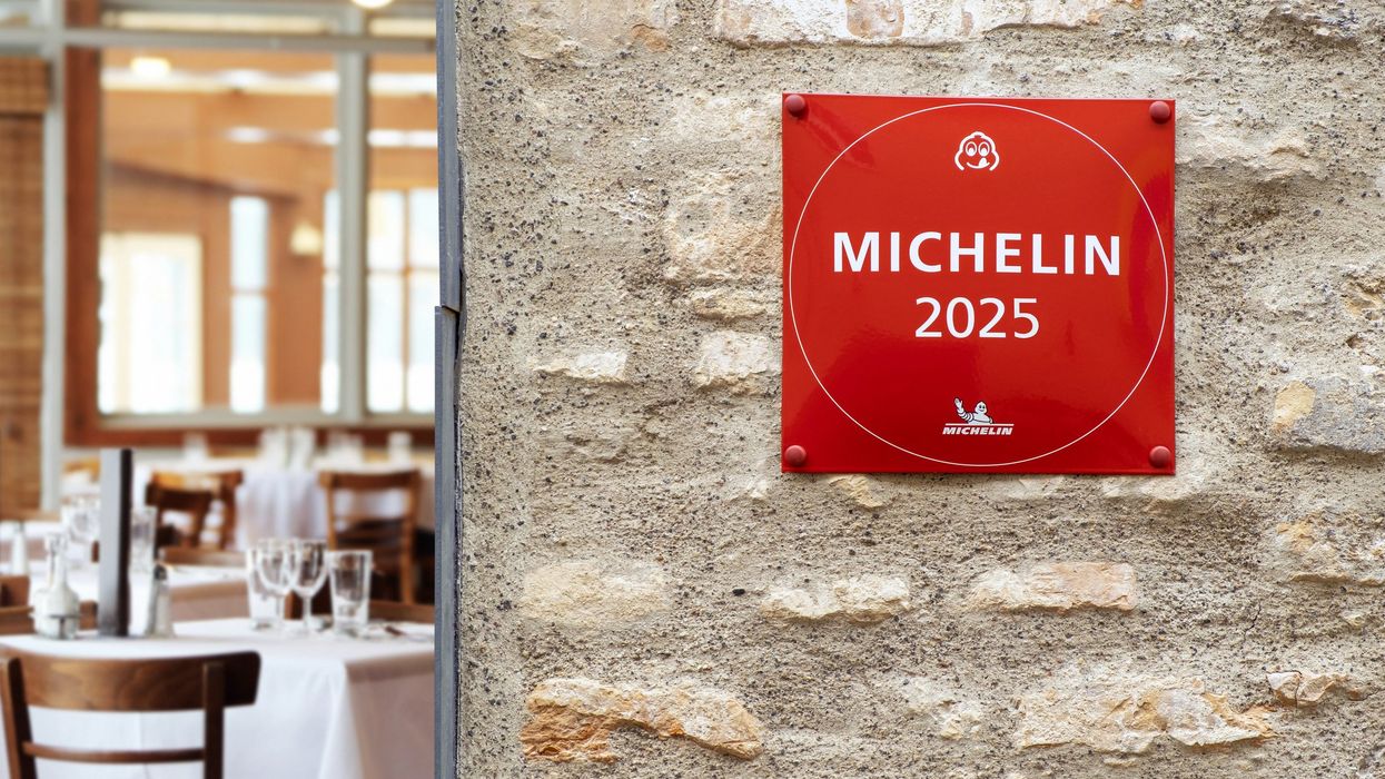 Plaque d’étoile du Guide Michelin signalant l’excellence d’un restaurant, accrochée à un mur de brique.