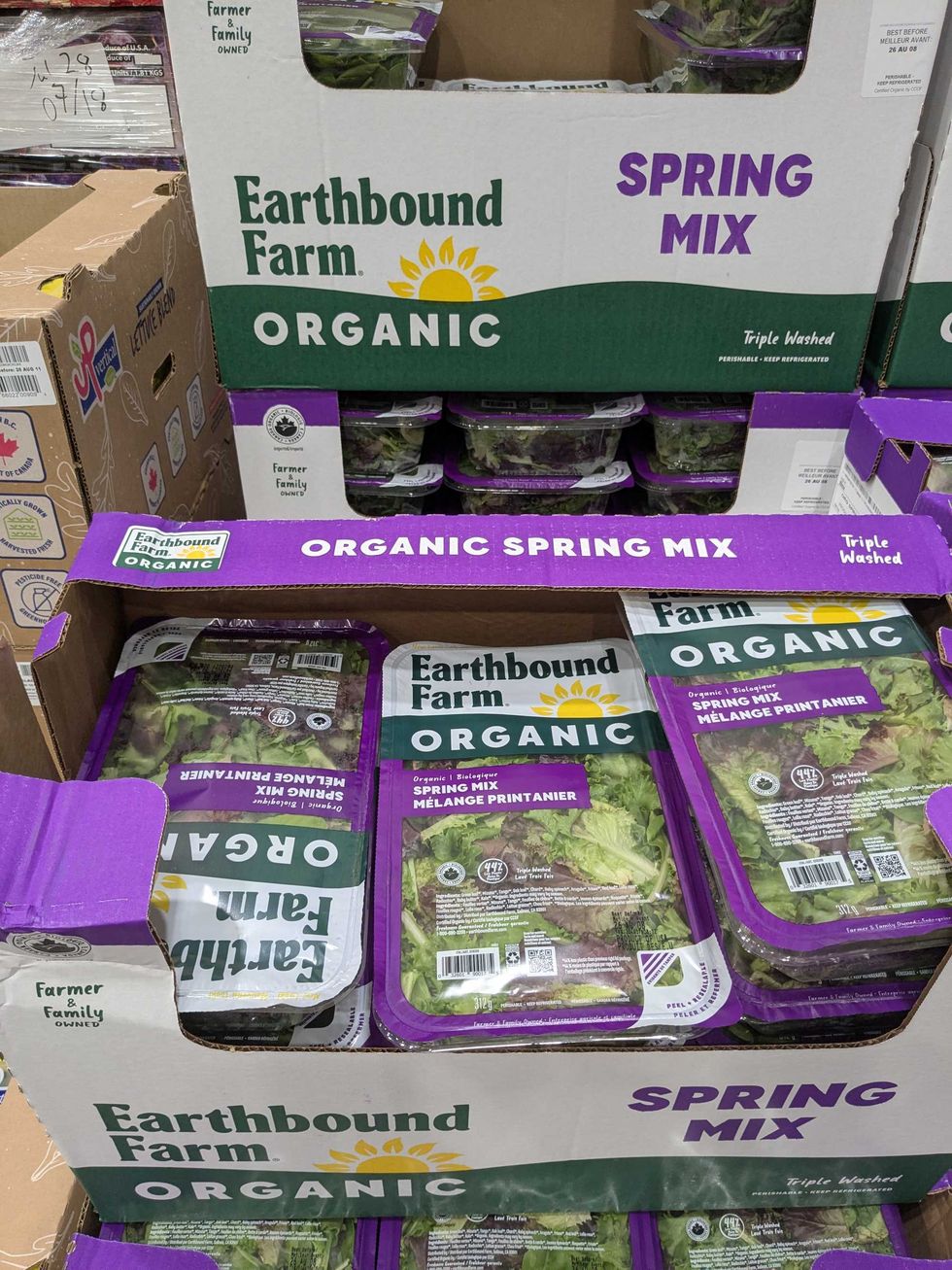 Plastic containers of spring mix in a box at Costco