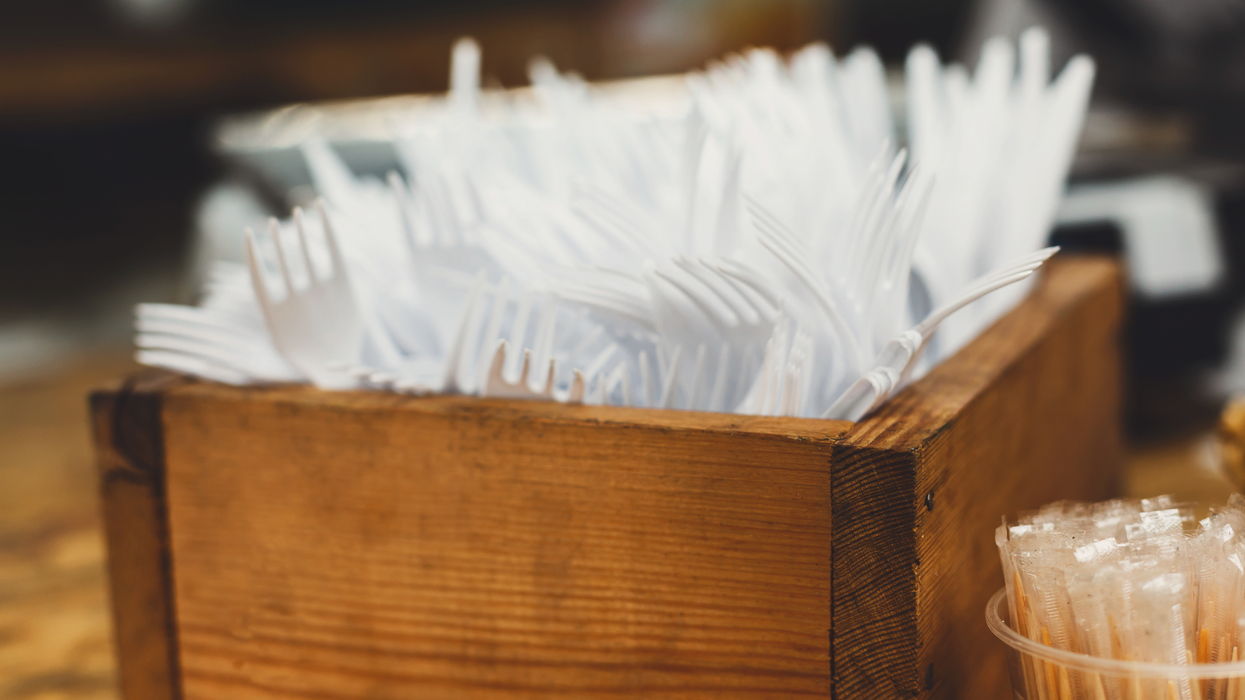 Plastic forks in a box at a restaurant.