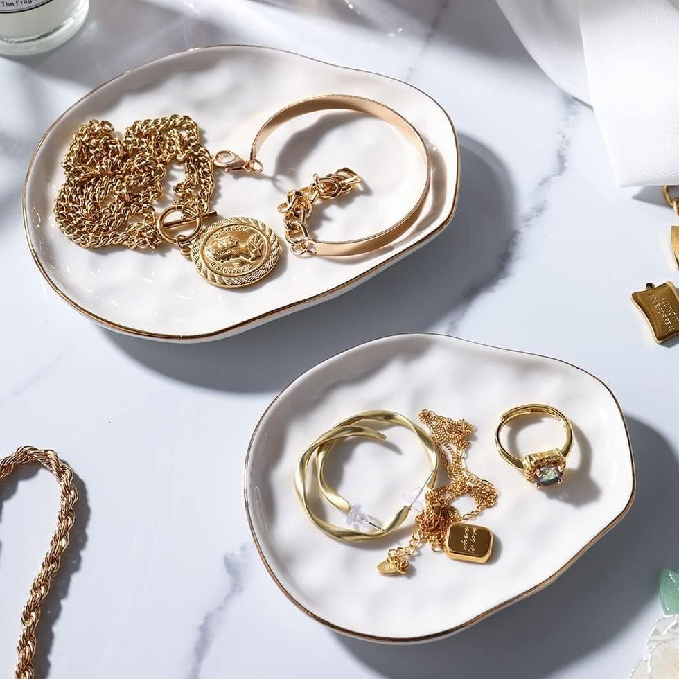 Plateaux \u00e0 bijoux blancs avec bordure dor\u00e9e.