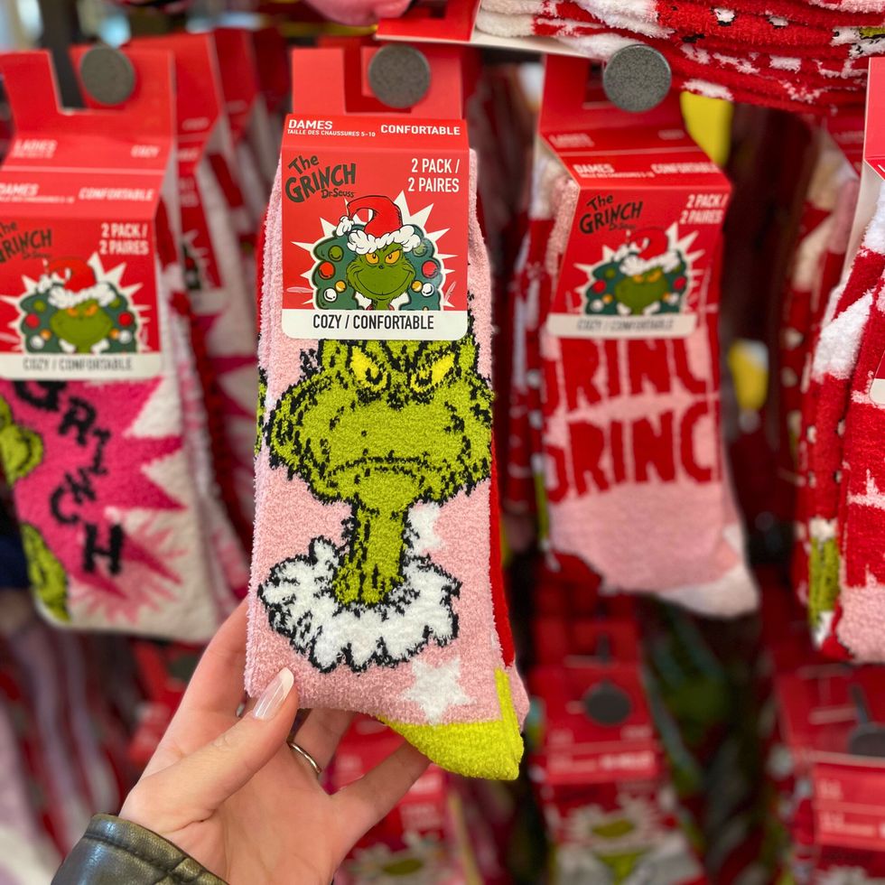 Plusieurs bas de No\u00ebl arborant l'effigie du Grincheux dispos\u00e9s sur une \u00e9tag\u00e8re murale.