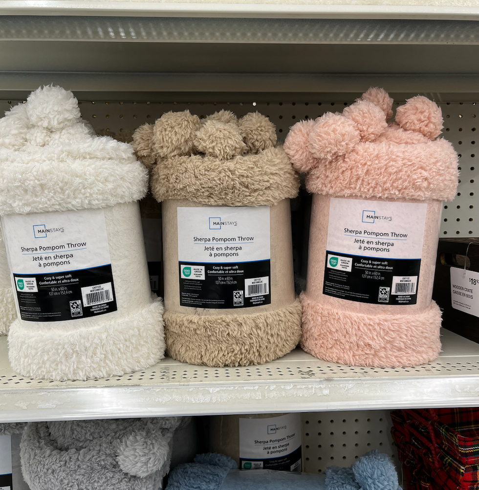 Plusieurs couvertures en sherpa sur une tablette.