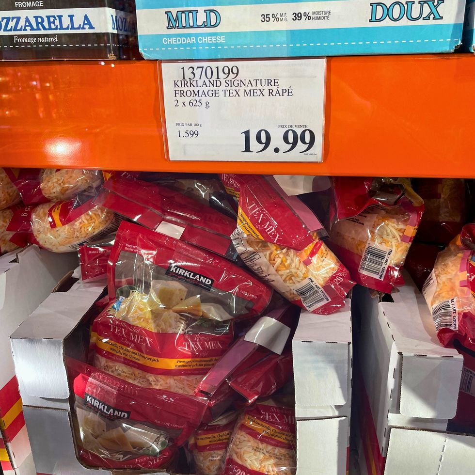Plusieurs grands sacs de fromage r\u00e2p\u00e9 tex-mex dispos\u00e9s dans une bo\u00eete \u00e0 l\u2019int\u00e9rieur d\u2019un r\u00e9frig\u00e9rateur chez Costco.