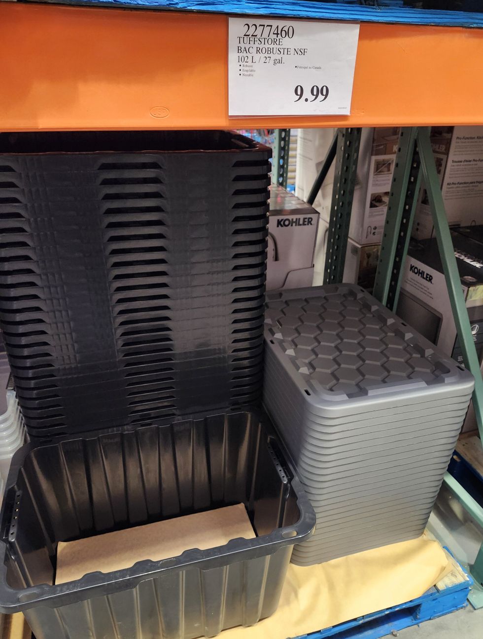 Plusieurs gros bacs de rangement noirs et leurs couvercles.