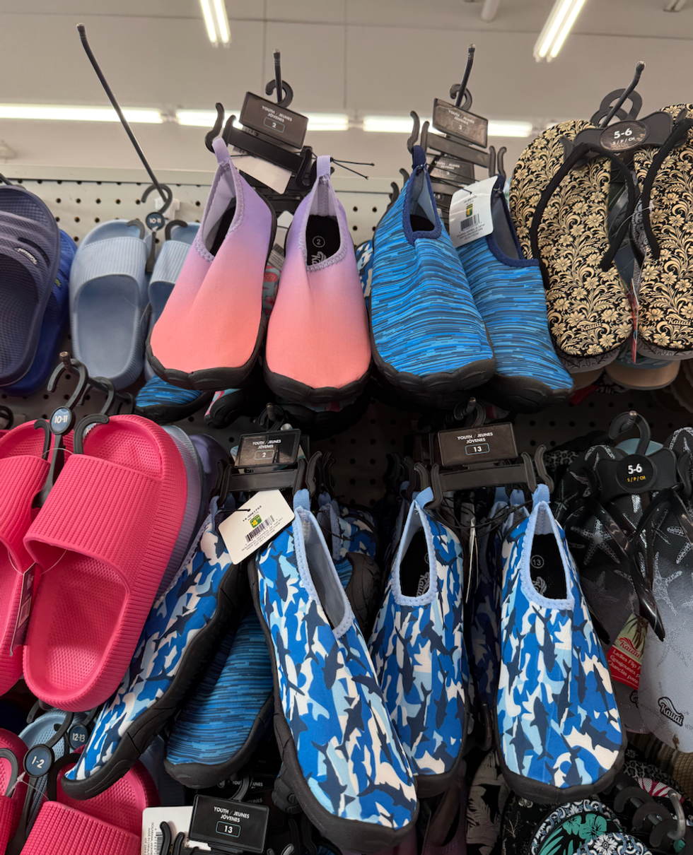 Plusieurs paires de souliers aquatiques color\u00e9s suspendus sur un mur de magasin.