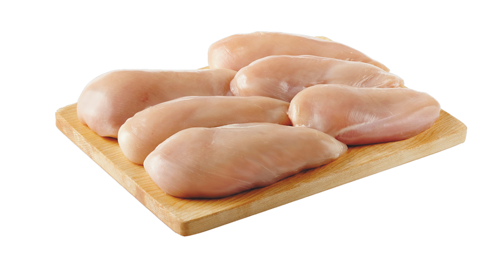 Poitrines de poulet sans peau sur une planche \u00e0 d\u00e9couper en bois.