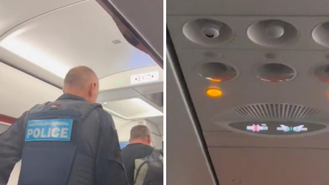 Police escort a passenger off a delayed Jetstar flight.