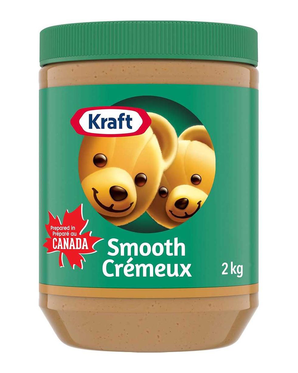 Pot de beurre d'arachides cr\u00e9meux Kraft avec son \u00e9tiquettes verte, sur fond blanc.