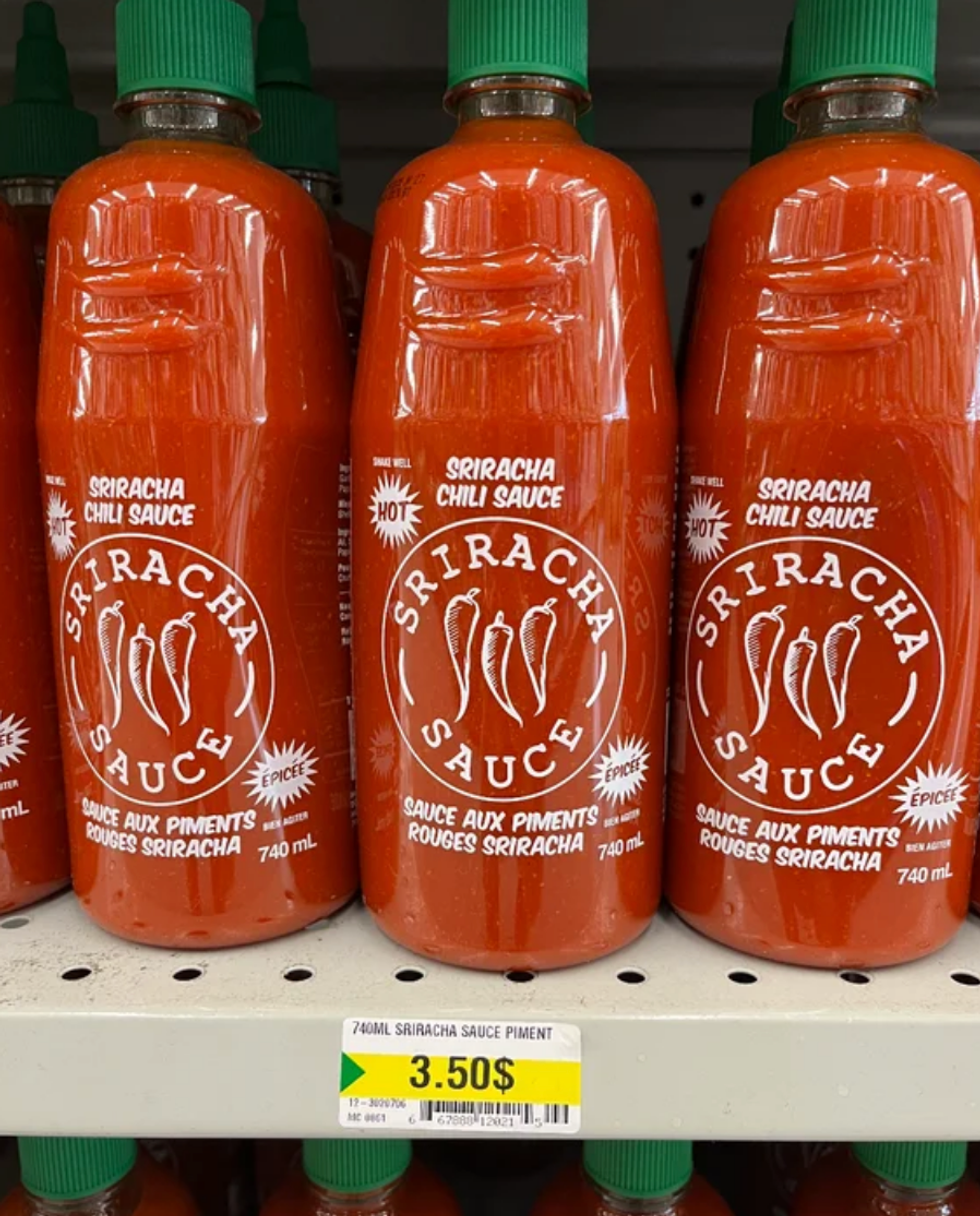 Pots de sauce sriracha sur les tablettes du Dollarama.