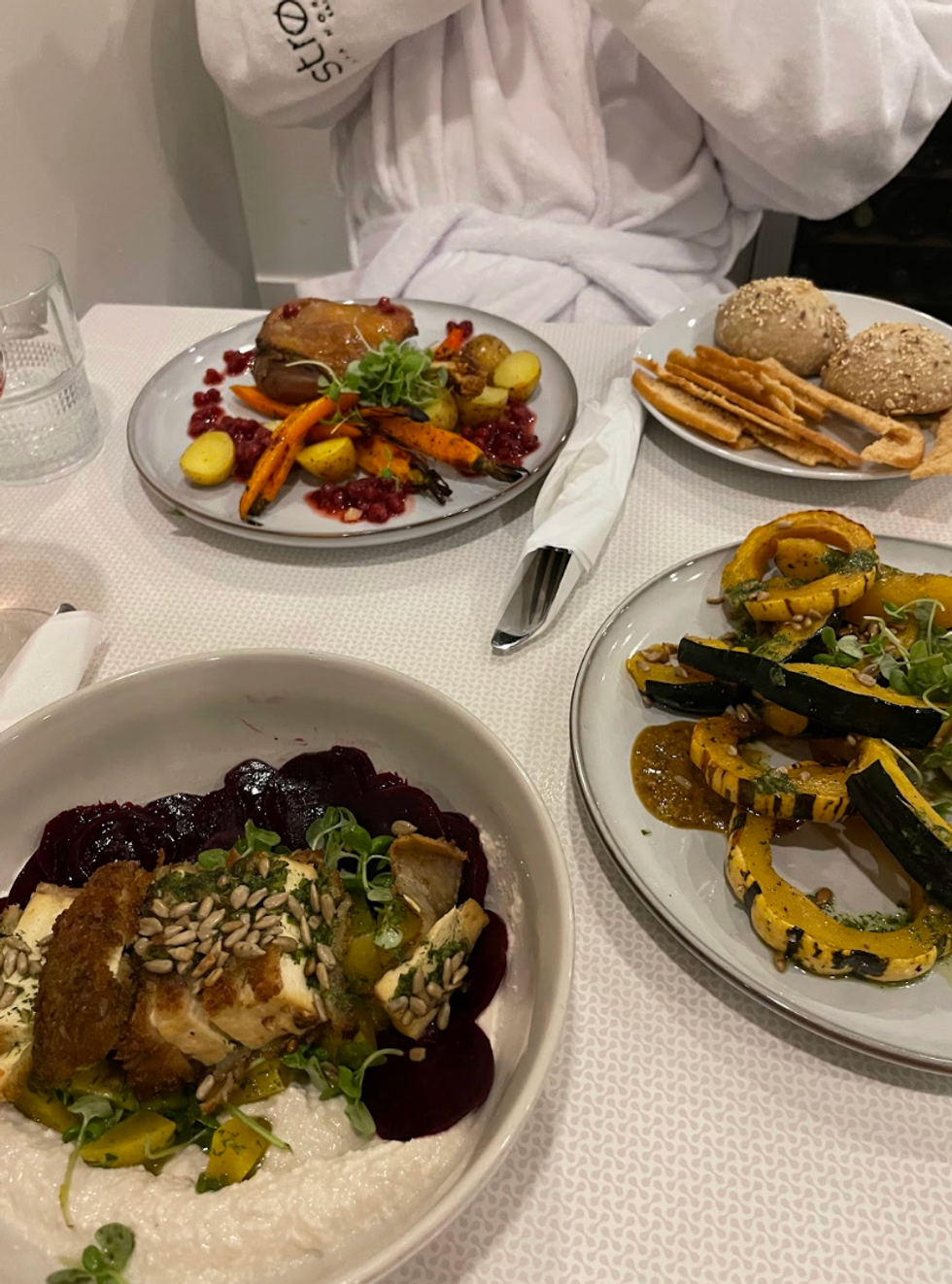 quatre assiettes sur une table avec une nappe blanche