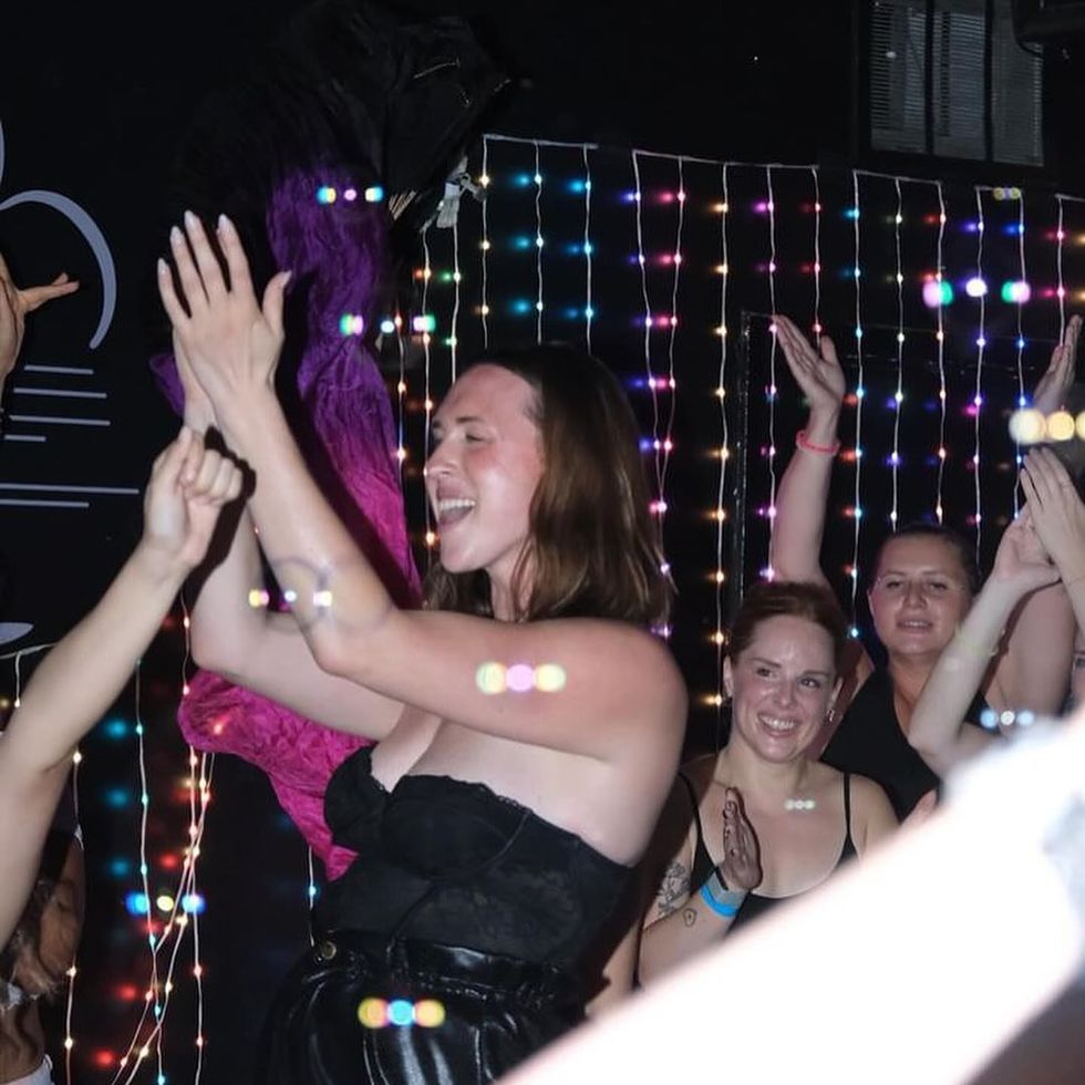 Rachel claps and cheers at a dance party.