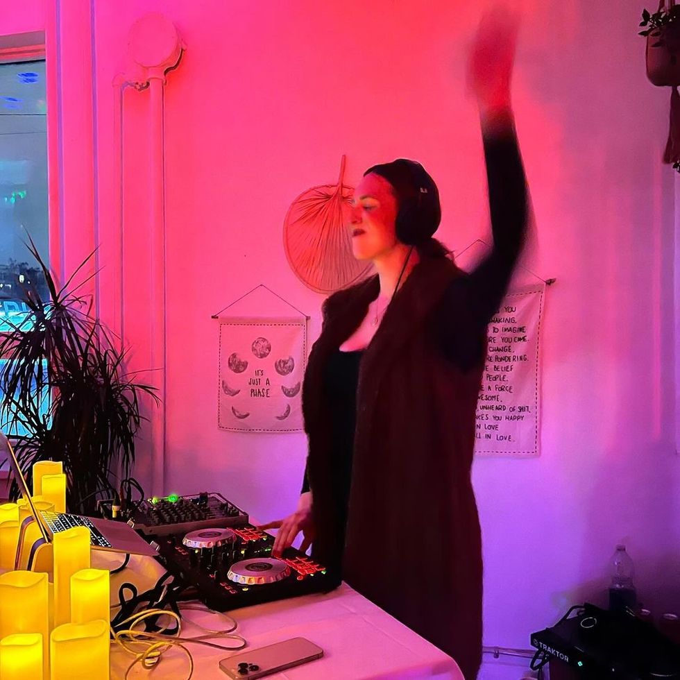 Rachel Molenda DJs surrounded by candles and lights.