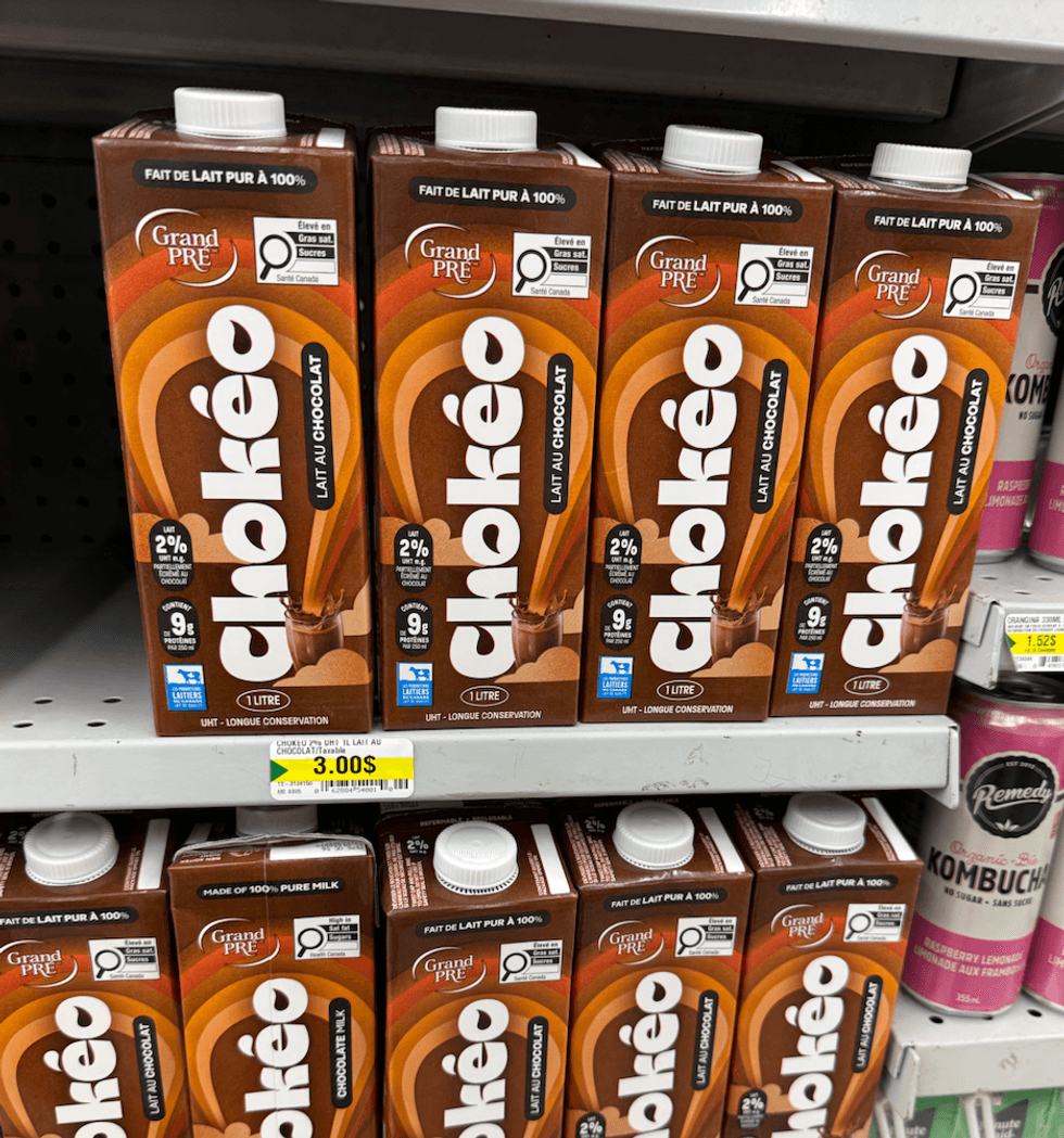Rang\u00e9e de cartons de lait au chocolat Grand Pr\u00e9 sur les tablettes du Dollarama.