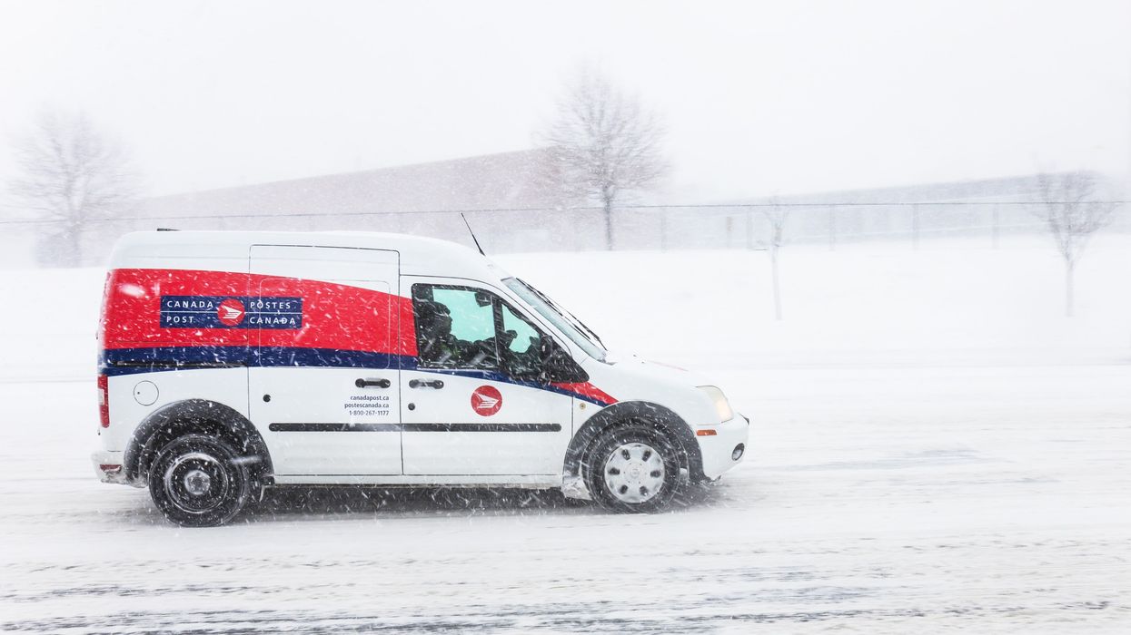 red and white canada post delivery vehicle on a snowy road