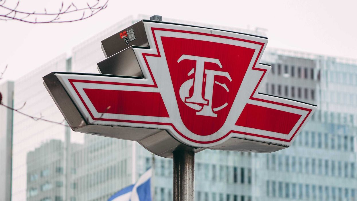 red and white ttc sign in front of a building in toronto