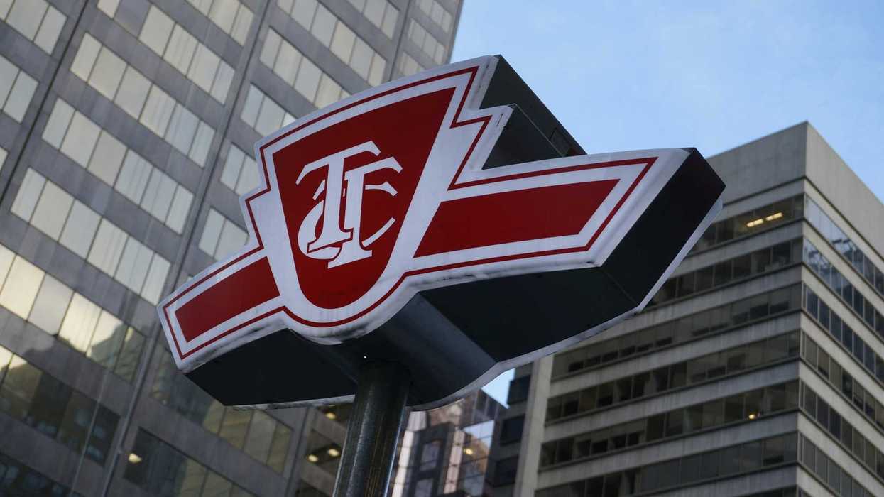 red and white ttc sign in front of buildings on toronto street